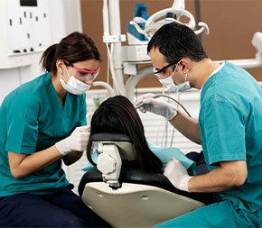 dental workers examining patient in chair