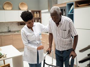 physical therapist helps senior man with walking