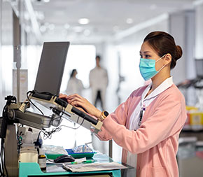 woman typing medical information into laptop