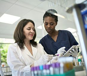 woman comparing test results with senior technician