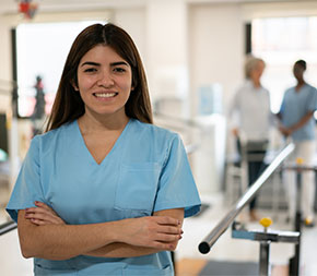 woman stand in front of physical therapy equipment