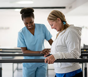 woman therapist helps woman walk