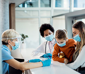 women health workers chat at station desk