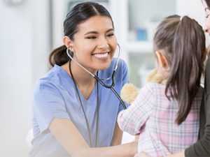 medical professional listens to childs heart with stethoscope