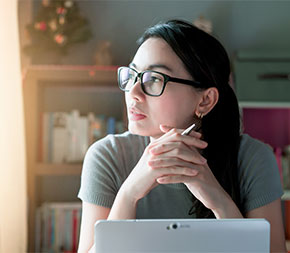 person in home office staring out window
