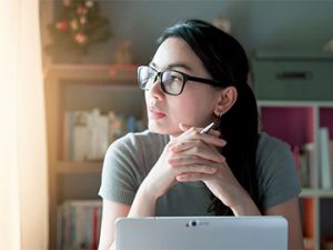 person in home office staring out window
