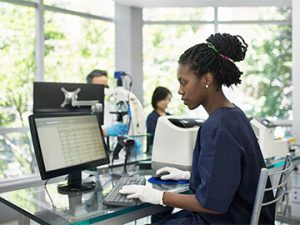 woman medical tech entering patient data in online health record