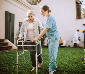 medical assistant helping patient using walker