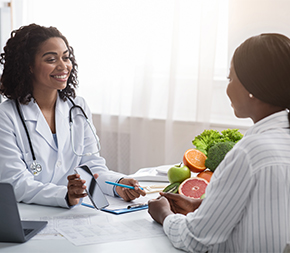 medical professional and client looking at phone and fruit on desk