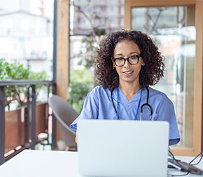 nurse doing course research on laptop