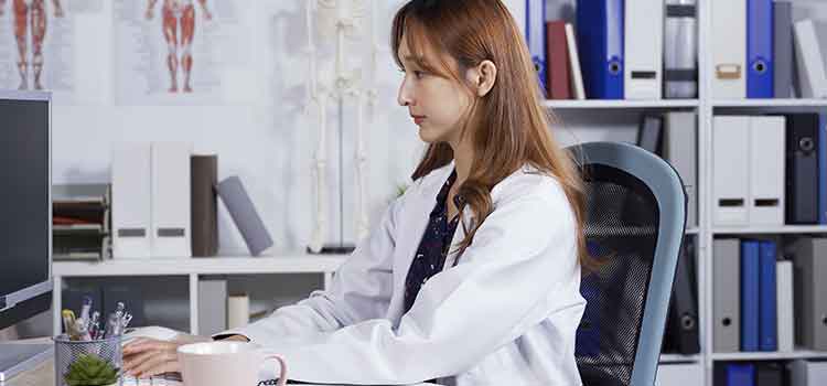 medical transcriptionist typing on computer