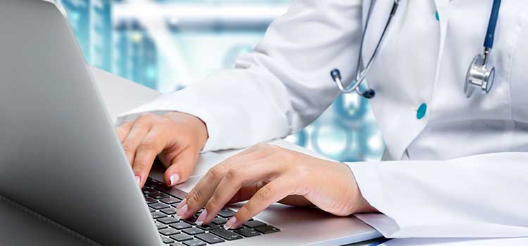 close up of hands typing on laptop