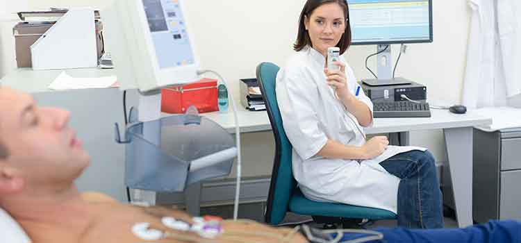 medical transcriptionist dictating notes with male patient in foreground