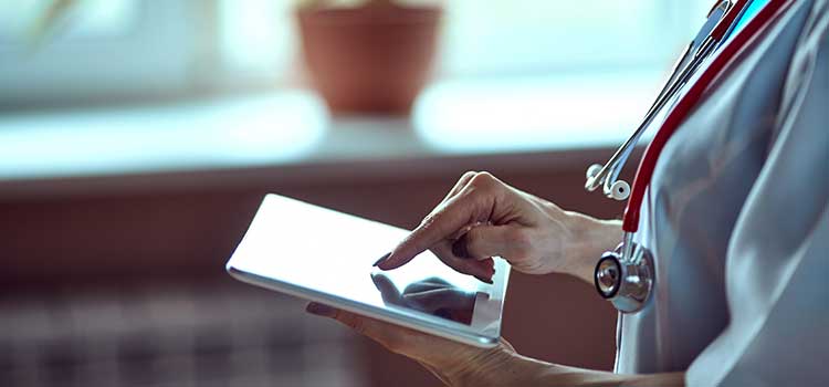 close up of medical worker viewing certifications on tablet