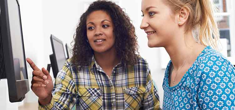 two women looking at computer screen