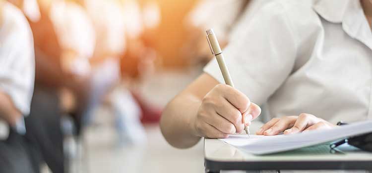 close up of person's hand writing in a notebook
