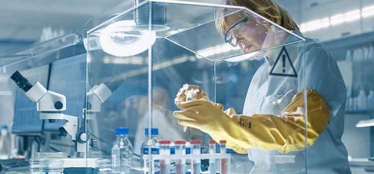 gowned pharmacy technician working with hazardous drugs