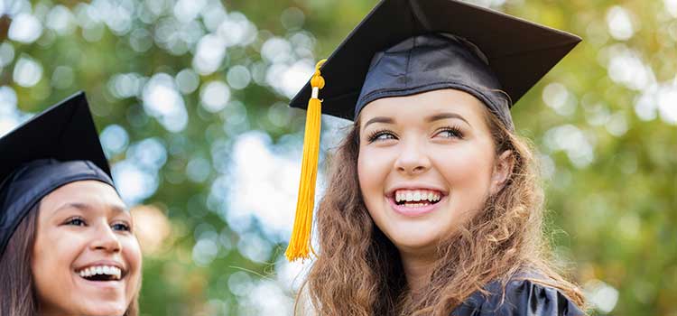 graduates in cap and gowns smiling after ceremony