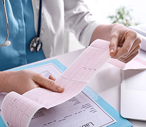 ekg tech reads test result on heart scan