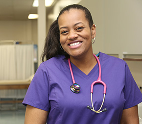 smiling medical assistant with stethoscope draped around neck