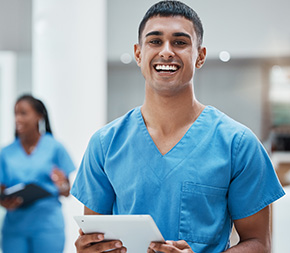 medical assistant holds tablet while doing rounds in hospital
