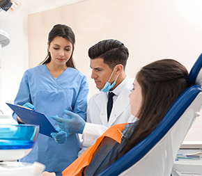ohio dental assistant shows dentist patient chart as he prepares to start dental exam