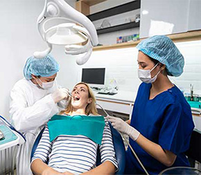 dental assistant rinses patient mouth as hygienist cleans patients teeth
