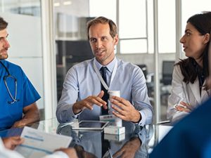 a healthcare administrator networks with other industry professionals at an organizational meeting