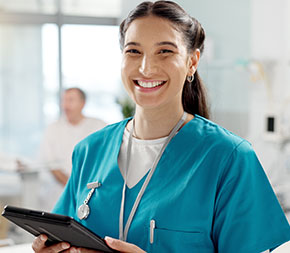 a certified medical assistant inputs patient data into an electronic tablet and smiles at the camera