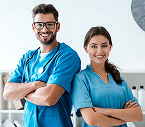 male medical assistant and female licensed practical nurse stand back to back with arms crossed