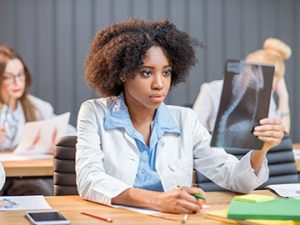 medical assisting student examines x-ray for challenging exam
