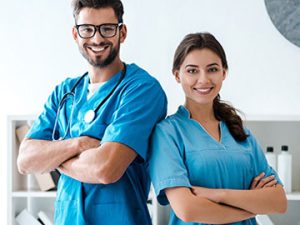 male medical assistant and female licensed practical nurse stand back to back with arms crossed