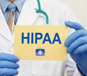 Dr. in lab coat and blue sanitary gloves holding yellow card with HIPPA written on it.