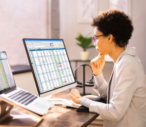 a medical coder works at a desktop computer inputting coding modifiers into reimbursement claims